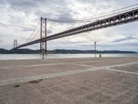 an area near the water and a bridge over it is empty and empty and there are no cars on it