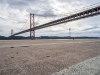 an area near the water and a bridge over it is empty and empty and there are no cars on it