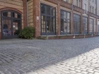 an empty building is shown with some signs on the sidewalk and a street light near by