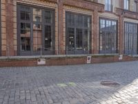 an empty building is shown with some signs on the sidewalk and a street light near by