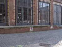 an empty building is shown with some signs on the sidewalk and a street light near by