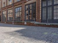 an empty building is shown with some signs on the sidewalk and a street light near by