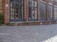 an empty building is shown with some signs on the sidewalk and a street light near by