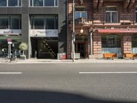 a building with a couple of benches in front of it that is empty on a city street