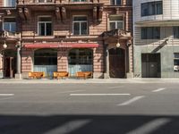 a building with a couple of benches in front of it that is empty on a city street