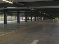 a large, empty building with two cars parked in it's carping area