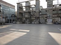 large empty building with scaffolds near the buildings in a public plaza area