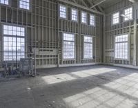 empty and big building being worked on, with large windows in front of a room full of steel rods