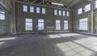 empty and big building being worked on, with large windows in front of a room full of steel rods