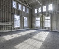 empty and big building being worked on, with large windows in front of a room full of steel rods