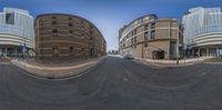 the street is full of empty empty buildings with tall towers behind it as seen in this fisheye lens