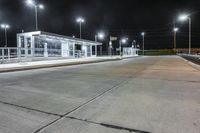 an empty bus station on a street lit by lights and night time lighting with snow