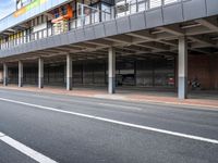 an empty bus stop at the side of a street in a city area with buildings behind it