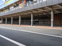 an empty bus stop at the side of a street in a city area with buildings behind it