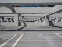 a car park with empty parking space and concrete buildings in the background, while no cars are out