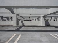 a car park with empty parking space and concrete buildings in the background, while no cars are out