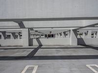 a car park with empty parking space and concrete buildings in the background, while no cars are out