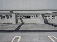 a car park with empty parking space and concrete buildings in the background, while no cars are out