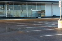 a empty car park with no parking on it and glass windows in the front of a business