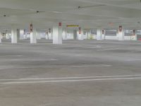 an empty car parking lot with no cars on it's sides and signs in red