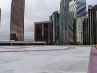 a city is empty, and the sky looks grey with clouds above it and there are three large buildings in the background