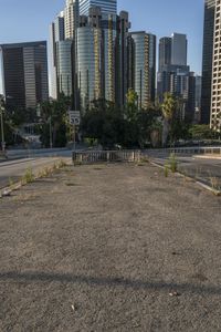 the parking lot at an empty city has many weeds on it, including the street signs