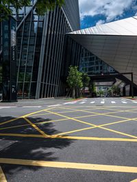 yellow lines in an empty city road near glass buildings on the horizon in the daytime