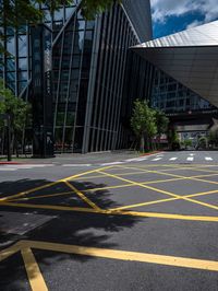 yellow lines in an empty city road near glass buildings on the horizon in the daytime