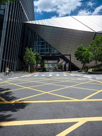 yellow lines in an empty city road near glass buildings on the horizon in the daytime