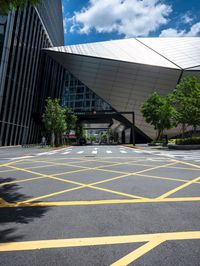 yellow lines in an empty city road near glass buildings on the horizon in the daytime