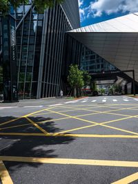 yellow lines in an empty city road near glass buildings on the horizon in the daytime