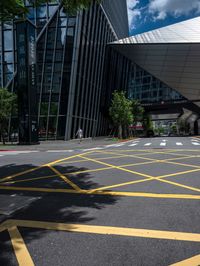 yellow lines in an empty city road near glass buildings on the horizon in the daytime