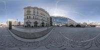 a 360 - lens of an empty city square and two tall buildings in the background