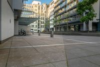 a parked bicycle sits in an empty city square on a sunny day from the ground to the right