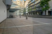 a parked bicycle sits in an empty city square on a sunny day from the ground to the right