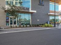 an empty city street in front of the entrance of an airport with glass windows and signage