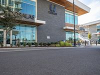 an empty city street in front of the entrance of an airport with glass windows and signage