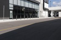 the empty city street in front of a building near a parking meter with windows, next to a street