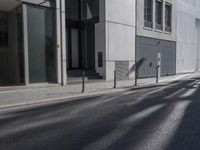 a city street with no cars passing by an empty building and a motorcycle parked next to it