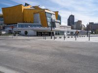 an empty city street with the buildings in the background behind it in front of an orange building