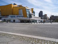 an empty city street with the buildings in the background behind it in front of an orange building