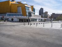 an empty city street with the buildings in the background behind it in front of an orange building