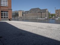 the city street is empty in the daylight time, and has buildings near it with water nearby