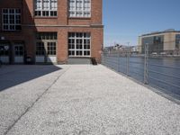 the city street is empty in the daylight time, and has buildings near it with water nearby