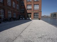 the city street is empty in the daylight time, and has buildings near it with water nearby