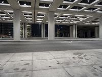 empty city street in concrete building structure with white ceiling tiles on roof area and people walking