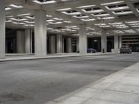 empty city street in concrete building structure with white ceiling tiles on roof area and people walking