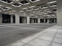 empty city street in concrete building structure with white ceiling tiles on roof area and people walking