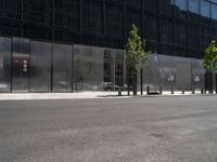 an empty city street with a black building behind it, and a parking space for two