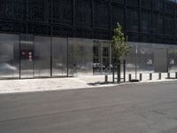 an empty city street with a black building behind it, and a parking space for two